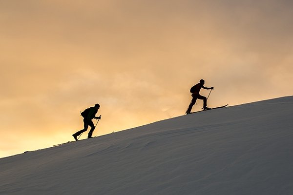 Two backcountry skiers during sunrise