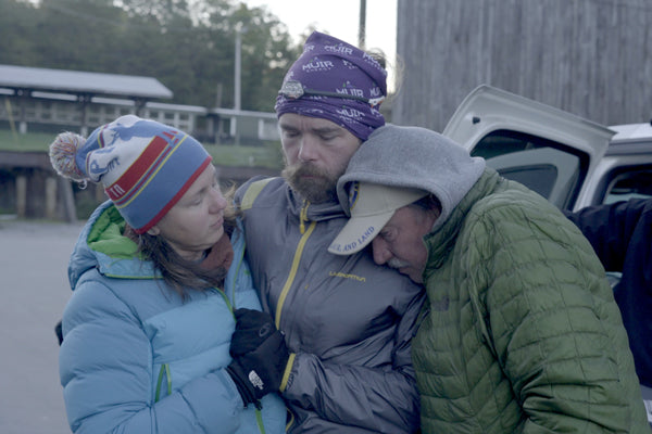 Jason Theinel embraced by two others