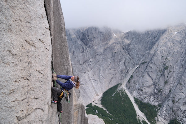 Climber leaning back on vertical granite face