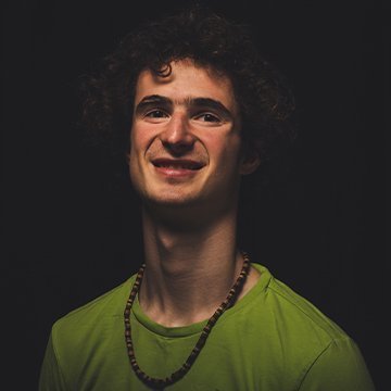 Man wearing a green shirt with a dark background