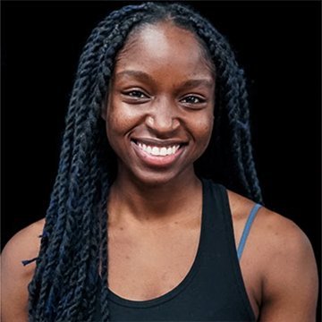 Woman with braided hair smiling against a black background