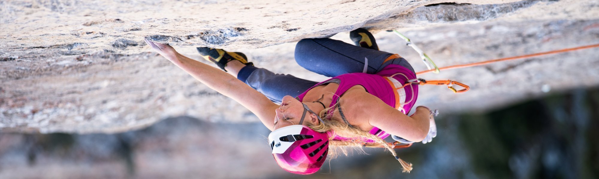 Person rock climbing on a steep cliff face.