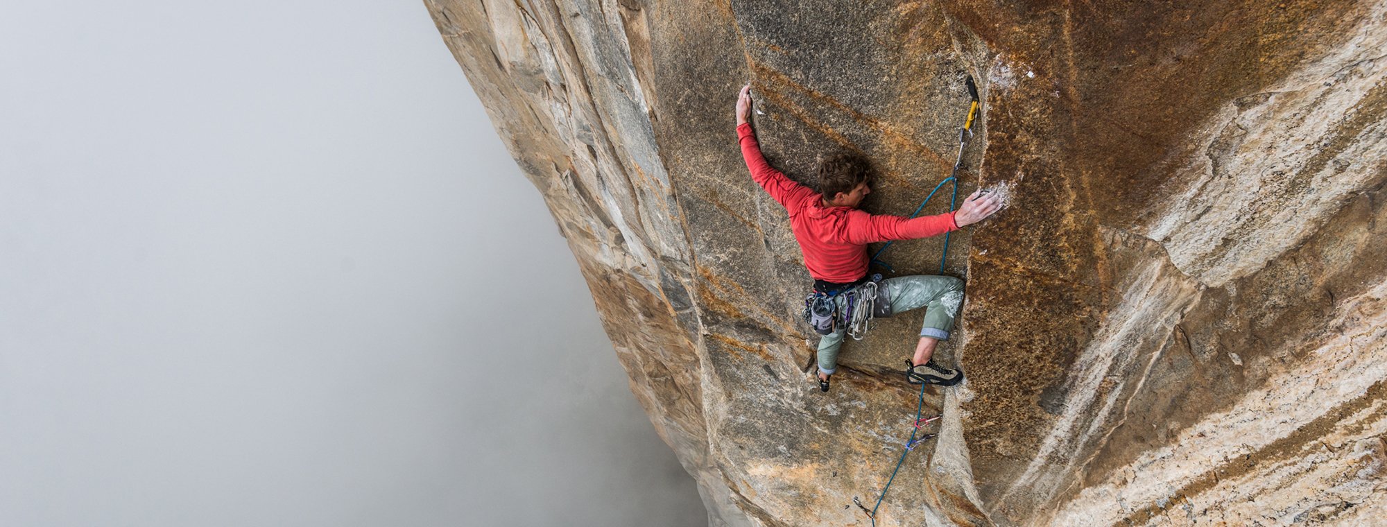Person climbing a rocky wall with a plain background