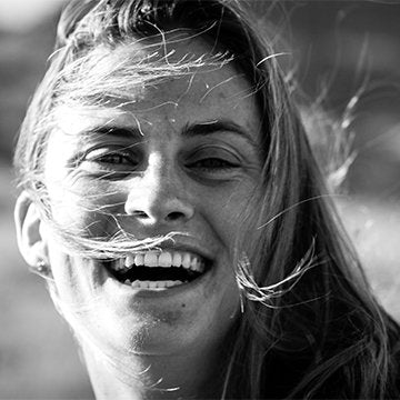 Black and white photo of a person with hair blowing in the wind