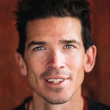 Close-up of a person with a neutral expression against a red background