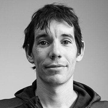 Black and white portrait of a person with a neutral expression on a plain background