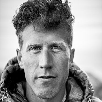 Black and white portrait of a person wearing a textured jacket.