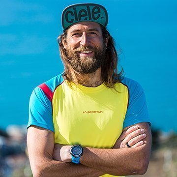 Man wearing a colorful shirt and cap with a blue sky background