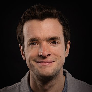 Man with a neutral expression against a black background