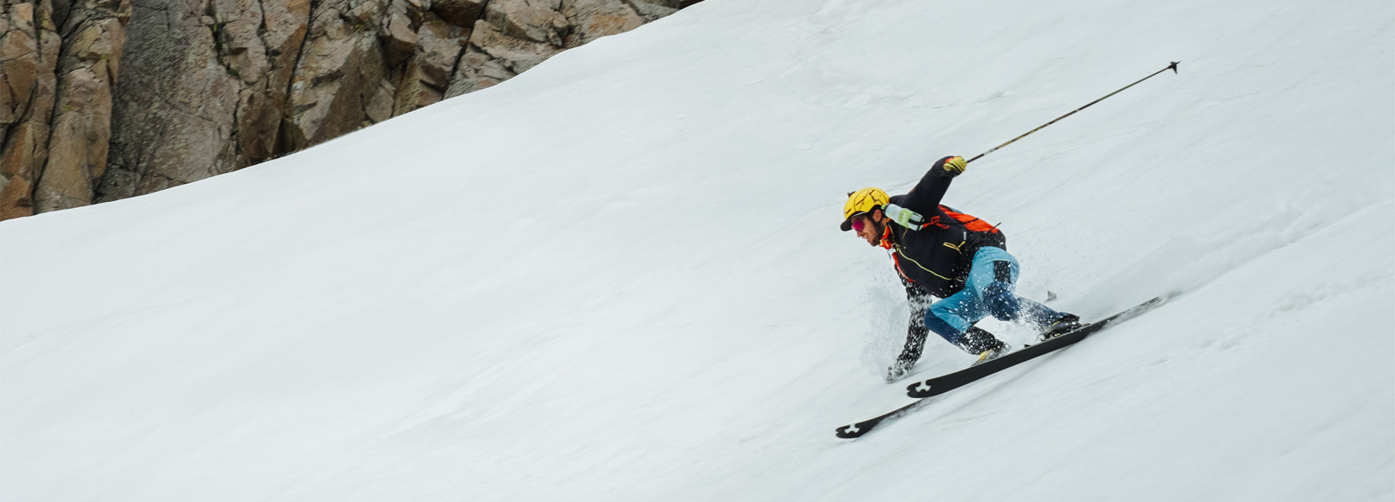 Skier in action on a snowy slope with a mountainous background