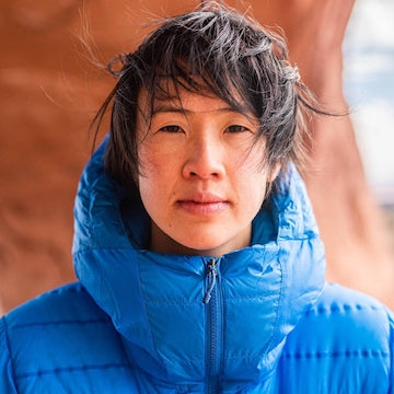 Person wearing a blue puffer jacket with a blurred background