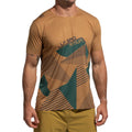 Un homme se tient debout, les bras détendus le long du corps. Il porte le La Sportiva Comp T-Shirt Men's (2025), un haut léger à manches courtes de couleur beige avec des motifs géométriques verts et "LA SPORTIVA" sur le devant, associé à un short beige.