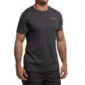 Un homme se tient debout sur un fond blanc, prêt à grimper, portant le T-shirt La Sportiva Dawn Wall Men's en noir avec un petit lettrage LA SPORTIVA jaune sur la poitrine gauche et un short noir.