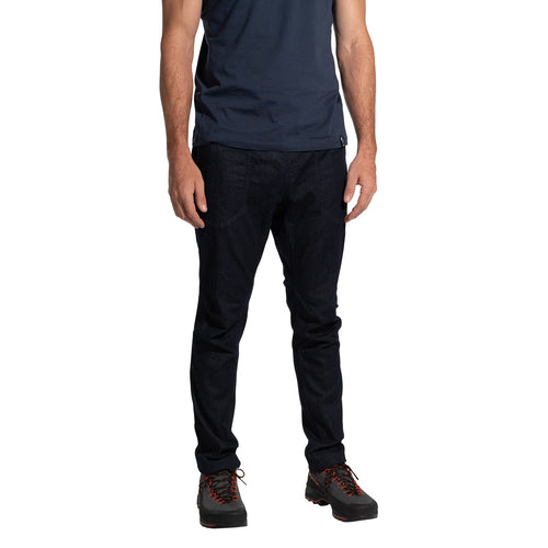 A man, head not visible, stands against a white background wearing a navy t-shirt, La Sportiva Cave Jeans Men's in dark blue, and black hiking shoes with red laces.