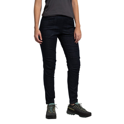 A person wearing La Sportiva Cave Jeans Women's in dark blue stands against a white background. The individual also wears a short-sleeve dark gray t-shirt and black hiking shoes with teal laces. The person's head is not visible.