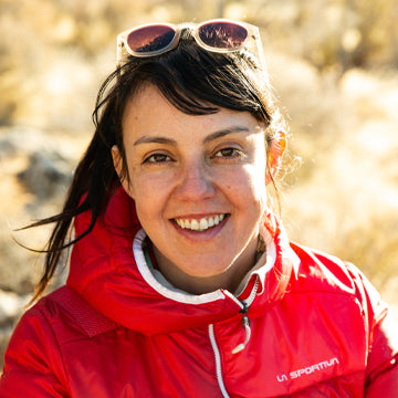 Person wearing a red jacket with sunglasses on their head, standing outdoors.