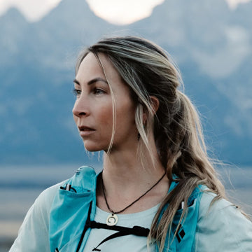 Woman with braided hair standing in front of mountains