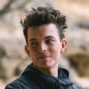 Person with spiky hair wearing a dark jacket outdoors