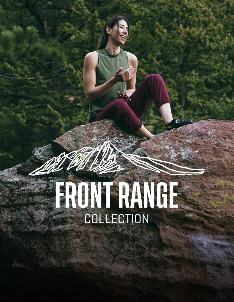A person sits on a large rock outdoors, smiling and gesturing with one hand. They wear a sleeveless green top and maroon pants. Trees and greenery are in the background. Text reads Front Range Collection with a mountain sketch above.