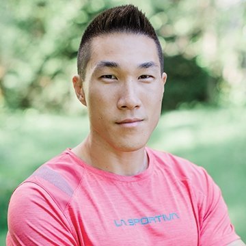 Person wearing a pink sports shirt with a blurred green background