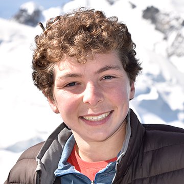 Person with curly hair standing in a snowy landscape