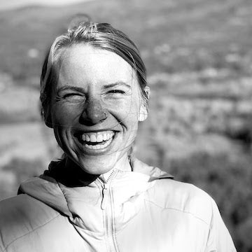 Black and white photo of a person outdoors with a scenic background