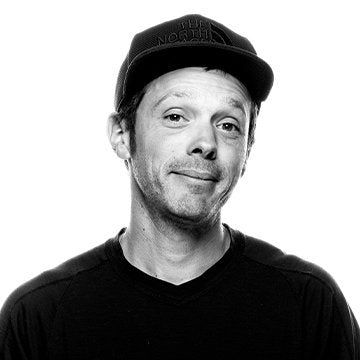 Black and white portrait of a person wearing a cap with 'The North Face' logo.