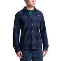 Un homme porte la chemise La Sportiva Rambler Flannel Shirt Men's, un mélange de coton et de polyester à carreaux bleu marine avec un col, une poche de poitrine, des boutons clairs et le logo LA SPORTIVA, sur un fond blanc.
