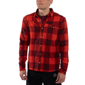 A man stands facing forward with his left hand relaxed by his side, wearing the La Sportiva Rambler Flannel Shirt Men’s in a red and black plaid pattern. The shirt is crafted from a soft cotton and polyester blend and features classic coconut buttons. He also wears black pants against a white background.
