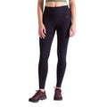 Une femme se tient debout sur un fond blanc, ne montrant que le bas de son torse et ses jambes dans un legging La Sportiva Cosmosis noir à taille haute, associé à des chaussures de randonnée foncées et à un top vert clair. L'image est coupée au niveau des épaules.