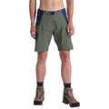 A woman wearing La Sportiva West Crest Shorts in olive green and navy, navy socks, and brown hiking boots stands facing forward against a white background. Only her body from the waist to feet is visible.