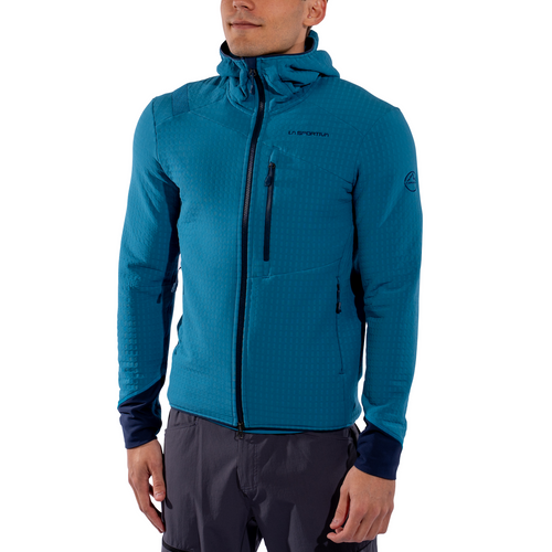 A person wearing the La Sportiva Bristen Thermal Hoody Men’s—a blue zip-up fleece jacket with a chest pocket—paired with gray pants, standing against a white background. Ideal for cold climates or technical mountaineering.