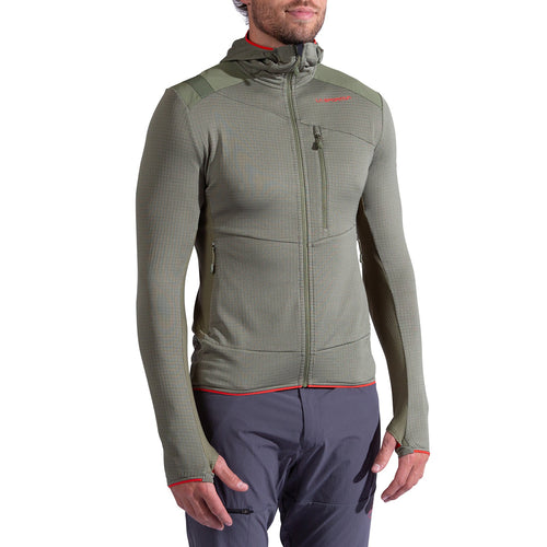 A person wears the La Sportiva Aequilibrium Thermal Hoody Men's in olive green—fitted with a front zipper, chest and side pockets, thumb holes, and red accents—perfect as a mountaineering midlayer. Paired with gray pants; head partially visible.