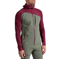 A person wearing the La Sportiva Aequilibrium Speed Jacket Men's in olive green and maroon, with a front zipper, chest pocket, and hood, stands against a plain white background.