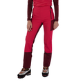 Une femme, vêtue d'un pantalon Ikarus de La Sportiva et d'un haut à manches longues assorti, ainsi que de chaussures de randonnée légères, se tient debout devant un fond blanc.