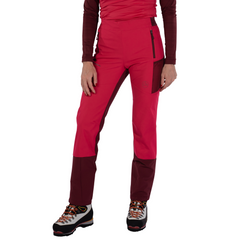 A woman is wearing La Sportiva Ikarus Pants and a matching long-sleeve top with lightweight hiking boots, standing against a white background.