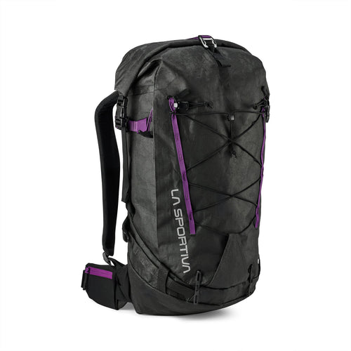 Le sac à dos Challenger 28 de La Sportiva est noir avec des accents violets, des élastiques à l'avant, des bretelles réglables, une ceinture de hanche rembourrée et "La Sportiva" imprimé verticalement sur le côté gauche de l'avant.