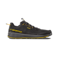A side view of the La Sportiva TX1 approach shoe in black with yellow accents, shown on a white background. The shoe features yellow “La Sportiva” logo text, a black Vibram MegaGrip sole, and visible laces.