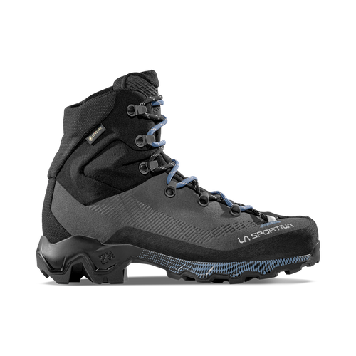 A profile view of the La Sportiva Aequilibrium Trek GTX Women’s boot showcases its black and gray design with blue laces, a rugged sole, and sturdy ankle support. Specifically designed for women, this mountaineering boot delivers reliable performance for backpacking expeditions and challenging outdoor terrain.