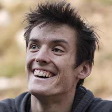 Person with spiky hair smiling outdoors