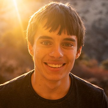 Person with a warm glow from sunlight, wearing a black shirt.