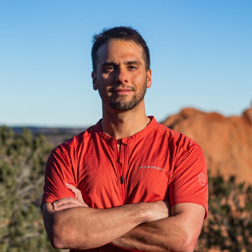 Man wearing a red shirt with a mountainous landscape in the background