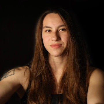 Woman with long hair and tattoos on a black background